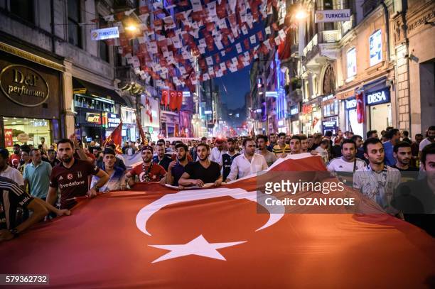 Turkish football supporters take part in a rally against the military coup on Taksim square in Istanbul on July 23, 2016. Turkey pushed on with a...