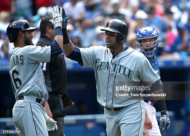 Nelson Cruz of the Seattle Mariners is congratulated by Luis Sardinas after hitting a three-run home run in the eighth inning during MLB game action...