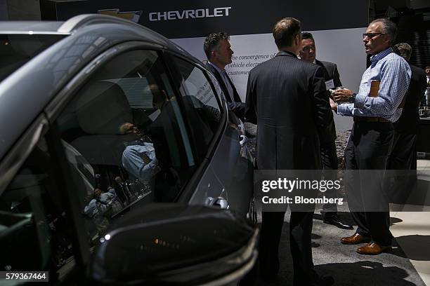 Attendees gather next to the new General Motors Co. Chevrolet Volt EV electric compact vehicle during the Billington Global Automotive Cybersecurity...