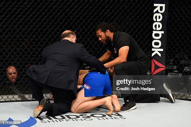 Referee Herb Dean instructs James Moontasri rests after being accidentally contacted below the waist by Alex Oliveira of Brazil in their welterweight...