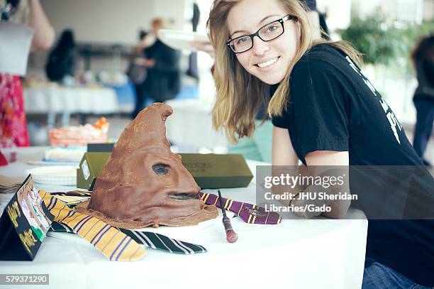 An undergraduate college student stands with her Harry Potter cake during Johns Hopkins University's annual "Read It And Eat It" Edible Book Festival...