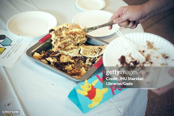 Undergraduate college students eat Winnie the Pooh cake during Johns Hopkins University's annual "Read It And Eat It" Edible Book Festival on the...