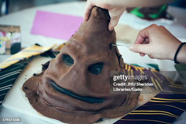 An undergraduate college student cuts her Harry Potter cake during Johns Hopkins University's annual "Read It And Eat It" Edible Book Festival on the...