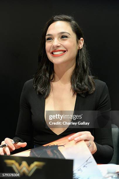 Actress Gal Gadot from the 2017 feature film Wonder Woman signs autographs for fans in DC's 2016 San Diego Comic-Con booth at San Diego Convention...