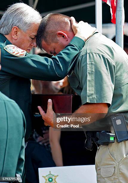 East Baton Rouge Parish Sheriff Sid Gautreaus holds a family member of East Baton Rouge Sheriff deputy Brad Garafola at the Istrouma Baptist Church...