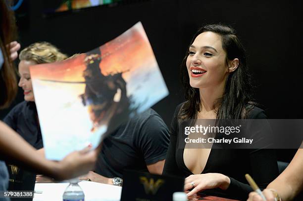 Actress Gal Gadot from the 2017 feature film Wonder Woman signs autographs for fans in DC's 2016 San Diego Comic-Con booth at San Diego Convention...