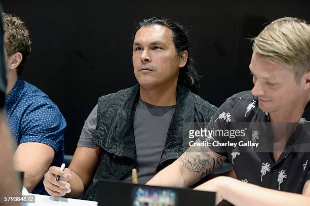 Actor Adam Beach and Joel Kinnaman from the cast of Suicide Squad film participates in an autograph session for fans in DC's 2016 Comic-Con booth at...