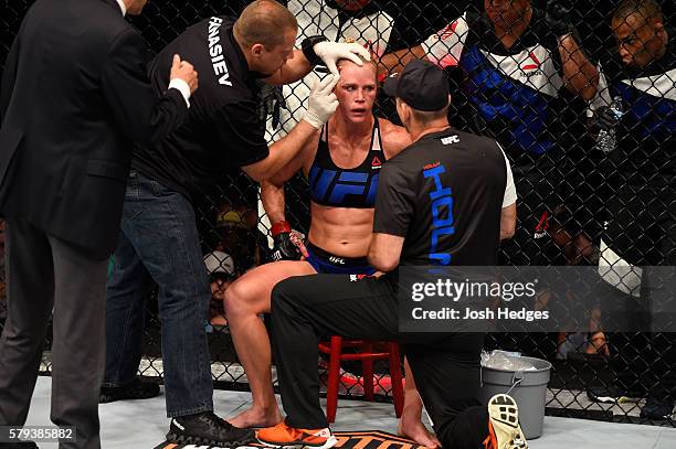 Holly Holm receives instruction from her corner between rounds against Valentina Shevchenko of Kyrgyzstan in their women's bantamweight bout during...