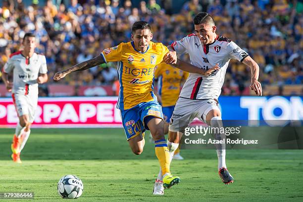 Javier Aquino of Tigres fights for the ball with Luis Reyes of Atlas during the 2nd round match between Tigres UANL and Atlas as part of the Torneo...