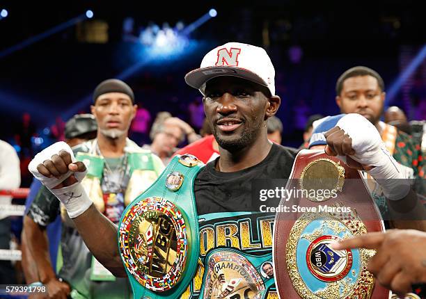 Junior welterweight champion Terence Crawford poses with belts after his unanimous decision victory over WBC champion Viktor Postol of Ukraine at MGM...
