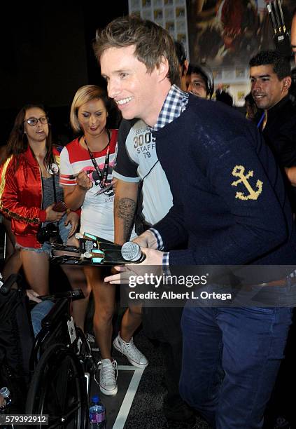 Actor Eddie Redmayne passes wands out to audience members at the Warner Bros. Presentation during Comic-Con International 2016 at San Diego...