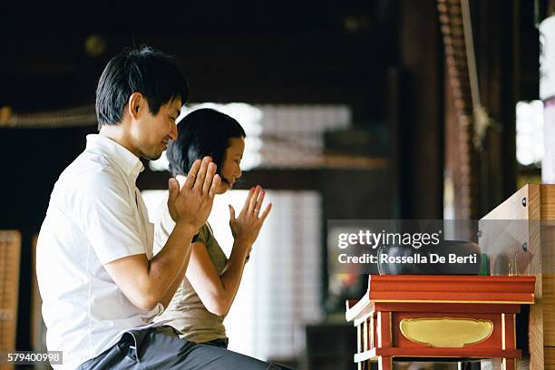 pareja japonesa rezando en un templo budista - shrine fotografías e imágenes de stock