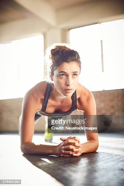 mujer flareoung haciendo ejercicio de tablón en el gimnasio - postura de plancha fotografías e imágenes de stock
