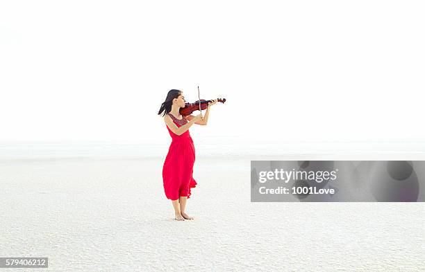 beautiful young woman playing violin on snow - beautiful woman violinist stock pictures, royalty-free photos & images