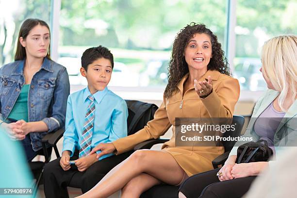 hispanic woman defending her son in meeting - defending stock pictures, royalty-free photos & images