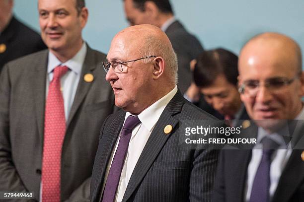 French Finance Minister Michel Sapin waits prior to a "family photo" at the G20 finance ministers meeting in Chengdu, in China's Sichuan province on...