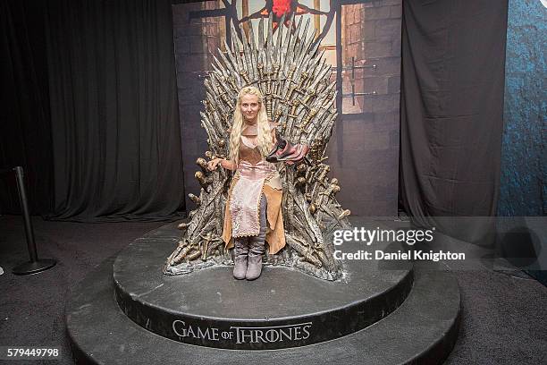 Liane McFadden, dressed as Daenerys Targeryan from HBO's hit series "Game of Thrones" poses for a photo on the Iron Throne at Comic-Con International...