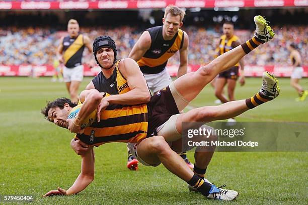 Ben Griffiths of the Tigers tackles Jordan Lewis of the Hawks during the round 18 AFL match between the Hawthorn Hawks and the Richmond Tigers at...