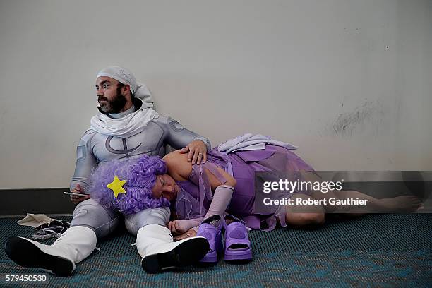 Derek Shackleton acts as a pillow for Faeran Adams who naps after a long day of cosplaying as Lumpy Space Princess from the Adventure Time cartoon at...
