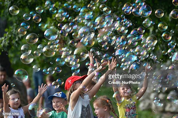 Group of young children enjoys a weekend soap bubbles games near the Wawel Royale Castle in Krakow. On Saturday, 23 July 2016, in Krakow, Poland.