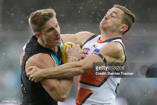 Hamish Hartlett of the Power is tackled by Devon Smith of the Giants during the round 18 AFL match between the Port Adelaide Power and the Greater...