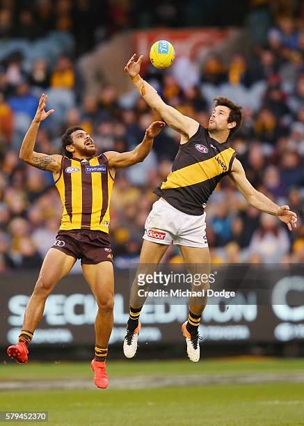 Trent Cotchin of the Tigers marks the ball one handed against Cyril Rioli of the Hawks during the round 18 AFL match between the Hawthorn Hawks and...