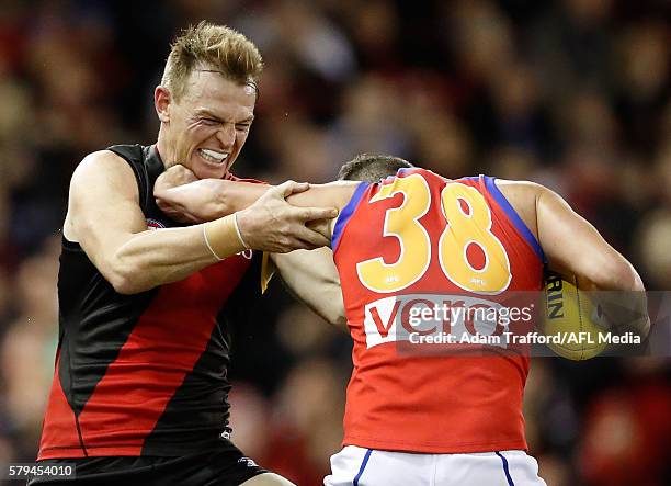 Tom Rockliff of the Lions is tackled by Brendon Goddard of the Bombers during the 2016 AFL Round 18 match between the Essendon Bombers and the...