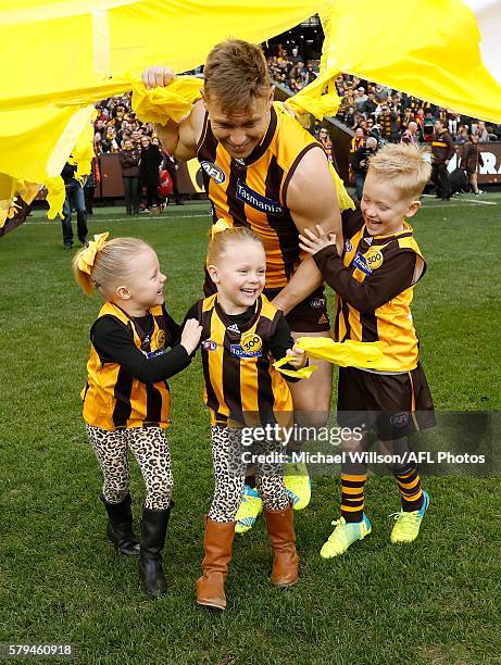 Sam Mitchell of the Hawks runs through the banner with his children for his 300th match during the 2016 AFL Round 18 match between the Hawthorn Hawks...