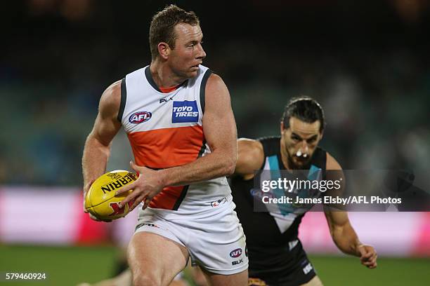 Steve Johnson of the Giants is chased by Kane Mitchell of the Power during the 2016 AFL Round 18 match between Port Adelaide Power and the GWS Giants...