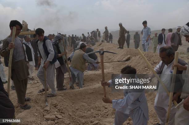 Afghan men dig graves for victims of a twin suicide attack, in Kabul on July 24, 2016. Kabul was plunged into mourning on July 24 after the deadliest...