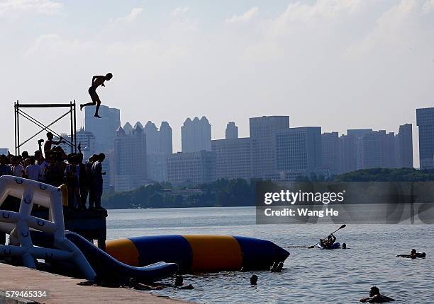 Man jumps into the East Lake on July 24, 2016 in Wuhan, Hubei province, China. This activity, which requires participants to ride their bikes and...