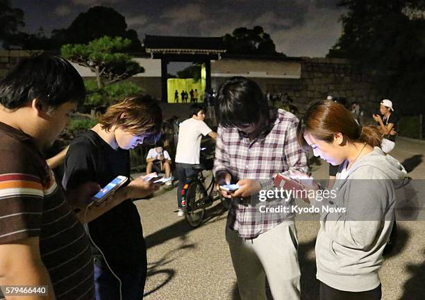 Over 100 people gather in Osaka Castle Park in Osaka in the early morning of July 24 to play the smash-hit "Pokemon Go" smartphone game. On the first...