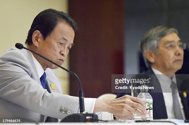 Japan's Finance Minister Taro Aso and Bank of Japan Governor Haruhiko Kuroda attend a press conference in Chengdu, Sichuan Province, southwest China,...
