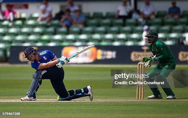 Liam Livingstone of England hits out while Pakistan wicket keeper Umar Siddiq looks on during the Triangular Series match between England Lions and...