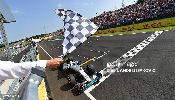 Mercedes AMG Petronas F1 Team's British driver Lewis Hamilton crosses the finish line to win the Formula One Hungarian Grand Prix at the Hungaroring...