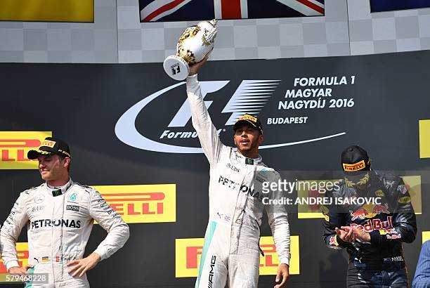 Mercedes AMG Petronas F1 Team's British driver Lewis Hamilton celebrates his victory on the podium with second placed Mercedes AMG Petronas F1 Team's...
