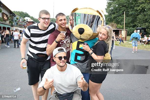 Visitors pose with Breuni-Baer, mascot of Breuninger, at the ParookaVille Festival on July 15, 2016 in Weeze, Germany.