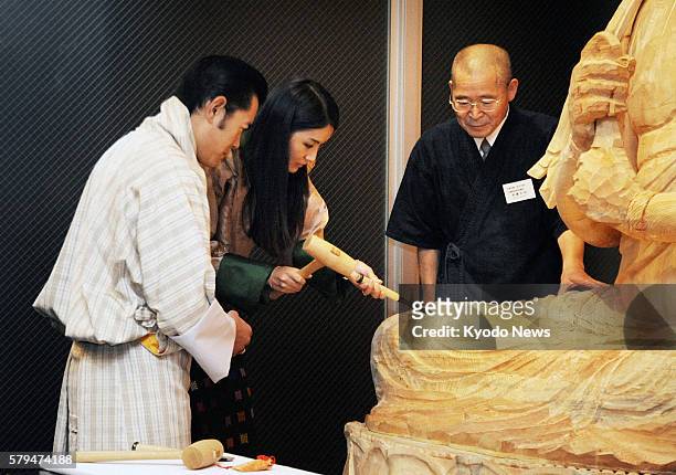 Japan - Bhutan's King Jigme Khesar Namgyel Wangchuck and Queen Jetsun Pema carve a Buddhist statue at the Gallery of Kyoto Traditional Arts & Crafts...