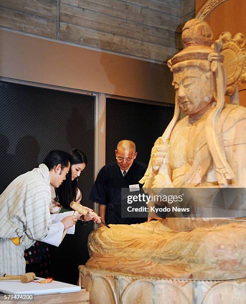 Japan - Bhutan's King Jigme Khesar Namgyel Wangchuck and Queen Jetsun Pema carve a Buddhist statue at the Gallery of Kyoto Traditional Arts & Crafts...