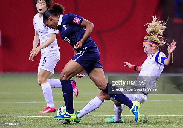 Midfielder Cho Sohyun of Korea Republic makes a sliding tackle on Marie Laure Delie of France during the FIFA 2015 Women's World Cup Round of 16...