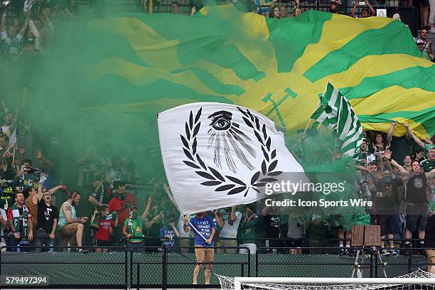 Portland fans in the Timbers Army celebrate a goal with large banners, flags, and smoke. The Portland Timbers FC hosted the Houston Dynamo at...