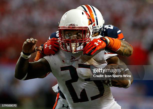 Louisville Cardinals running back Brandon Radcliff is tackled by Auburn Tigers defensive back Tray Matthews in the Auburn Tigers 31-24 victory over...