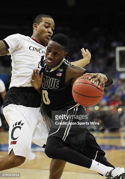 Purdue Boilermakers guard Jon Octeus drives to the basket against Cincinnati Bearcats guard Troy Caupain in a second-round NCAA Tournament game...