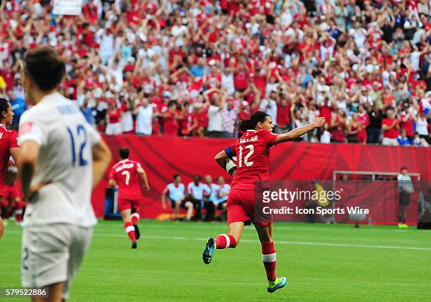 Canadian forward Christine Sinclair runs the ball back to midfield and eggs on fans after scoring late in the first half on Saturday during the...
