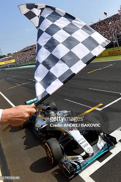 Mercedes AMG Petronas F1 Team's British driver Lewis Hamilton crosses the finish line to win the Formula One Hungarian Grand Prix at the Hungaroring...