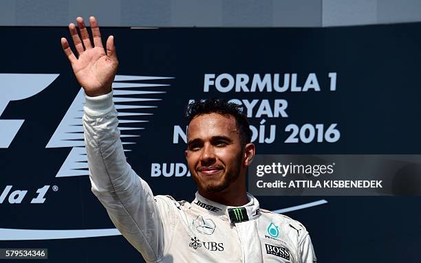 Mercedes AMG Petronas F1 Team's British driver Lewis Hamilton celebrates his victory on the podium after the Hungarian Formula One Grand Prix at the...