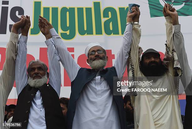Pakistani Ameer of the Jamaat e Islami organisation Senator Sirajul Haq and Hizbul Mujahideen chief Syed Salahuddin join hands as they wave to...