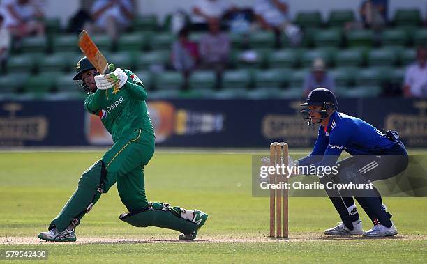 Jaahid Ali of Pakistan hits out while England Wicket keeper Sam Billings looks on during the Triangular Series match between England Lions and...