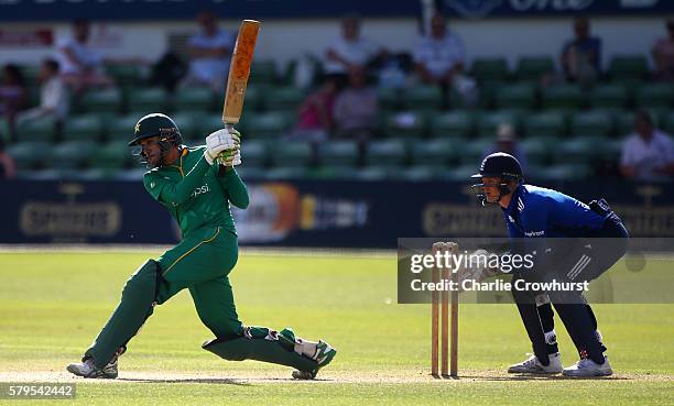 Jaahid Ali of Pakistan hits out while England Wicket keeper Sam Billings looks on during the Triangular Series match between England Lions and...