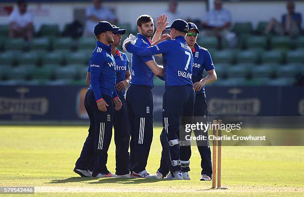 Mark Wood of England celebrates with team mates after taking the wicket of Jaahid Ali of Pakistan during the Triangular Series match between England...